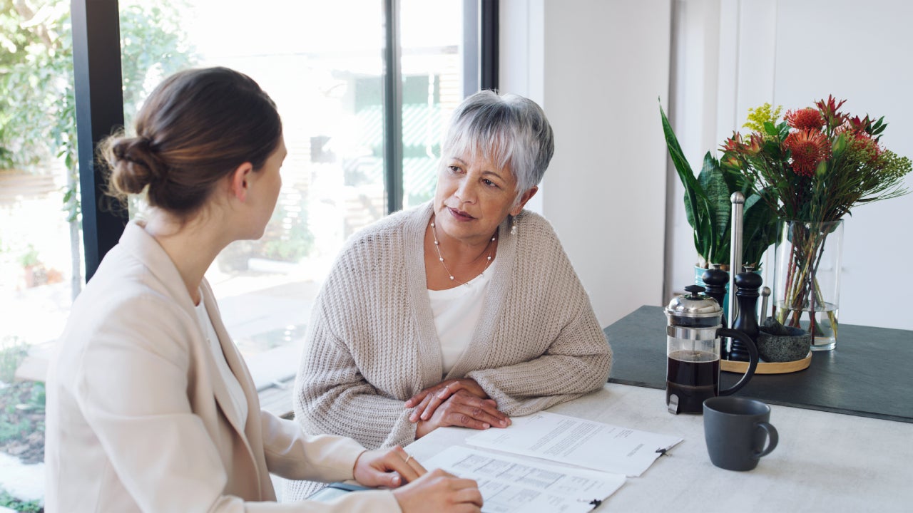An older woman talks with a younger woman about her finances.