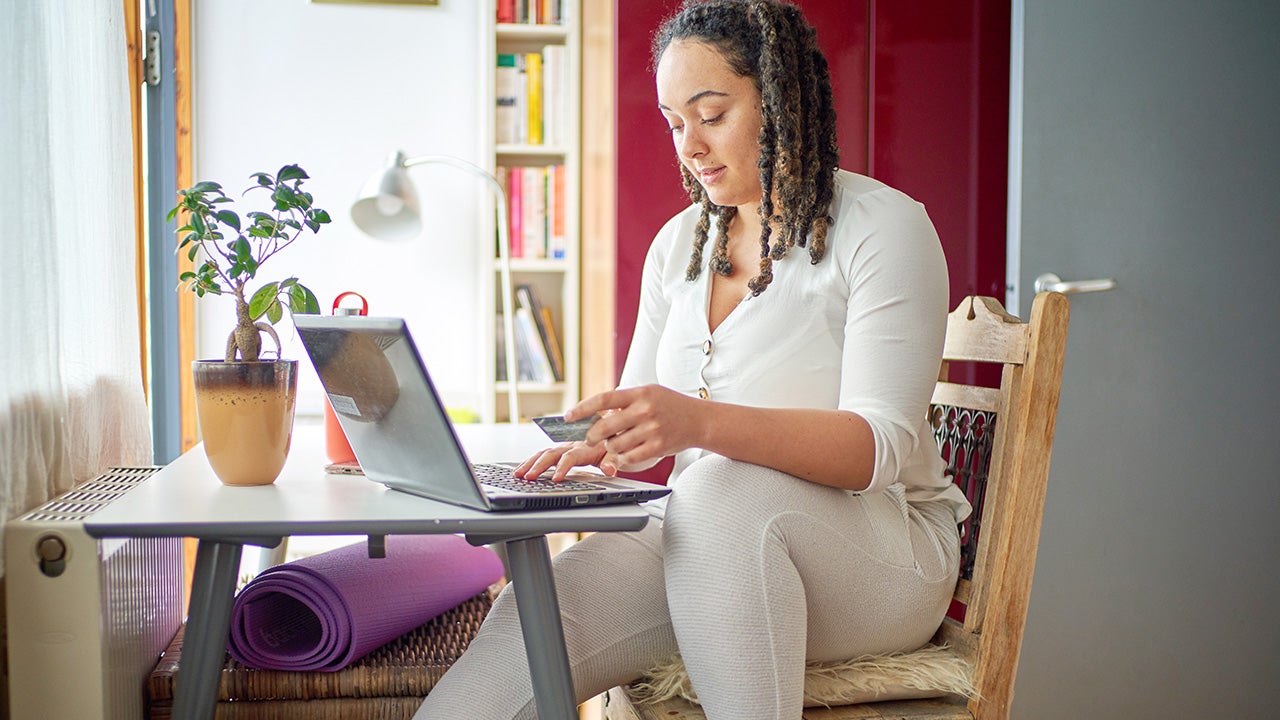 woman using a credit card at home`
