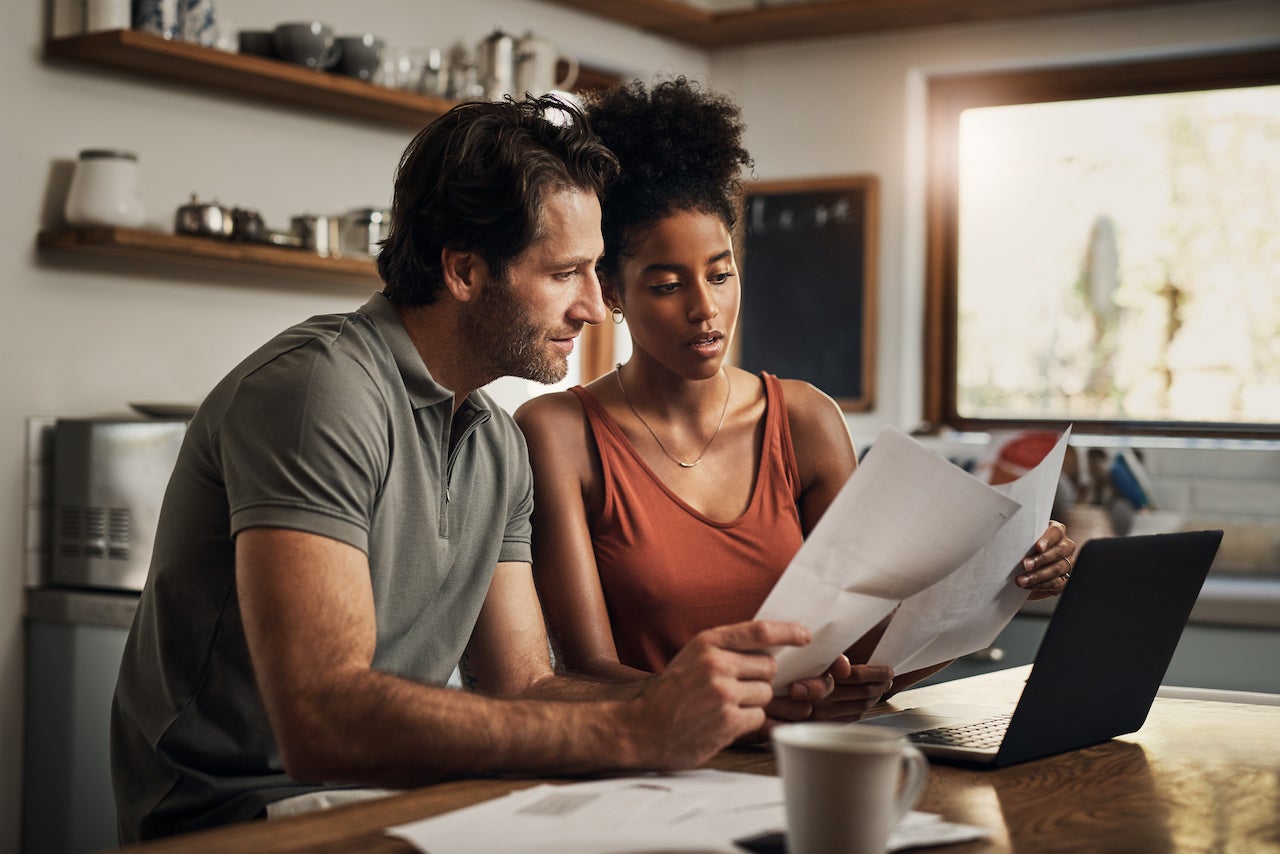 is 700 a good credit score to buy a house - couple doing budget in kitchen
