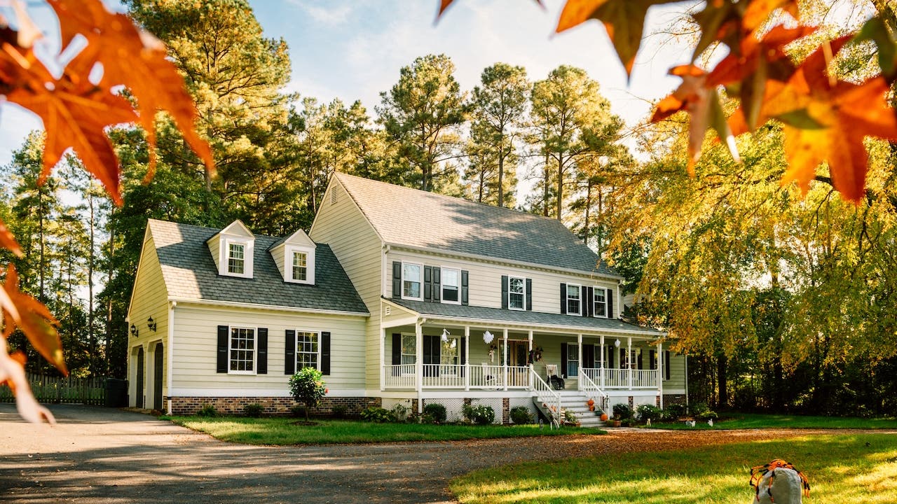 large colonial style house with front porch and 2 car garage